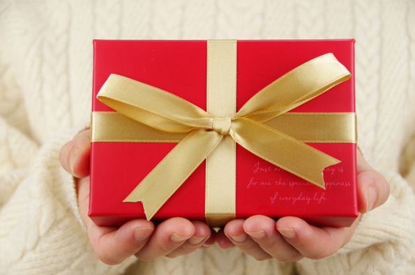 バレンタインデーの日に男性に贈るギフトの箱を手に持っている女性の画像